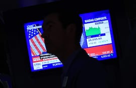 Un televisor muestra la noticia del aumento de las tasas de interés por parte de la Reserva Federal de EE. UU. mientras los operadores trabajan en la sala de operaciones de la Bolsa de Nueva York (NYSE) el 16 de septiembre de 2026.