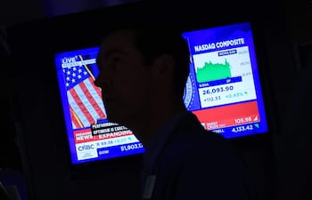 Un televisor muestra la noticia del aumento de las tasas de interés por parte de la Reserva Federal de EE. UU. mientras los operadores trabajan en la sala de operaciones de la Bolsa de Nueva York (NYSE) el 16 de septiembre de 2026.