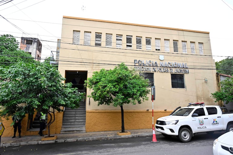 Fachada de la Comisaría 3era en Asunción con vehículo policial estacionado y árboles alrededor.