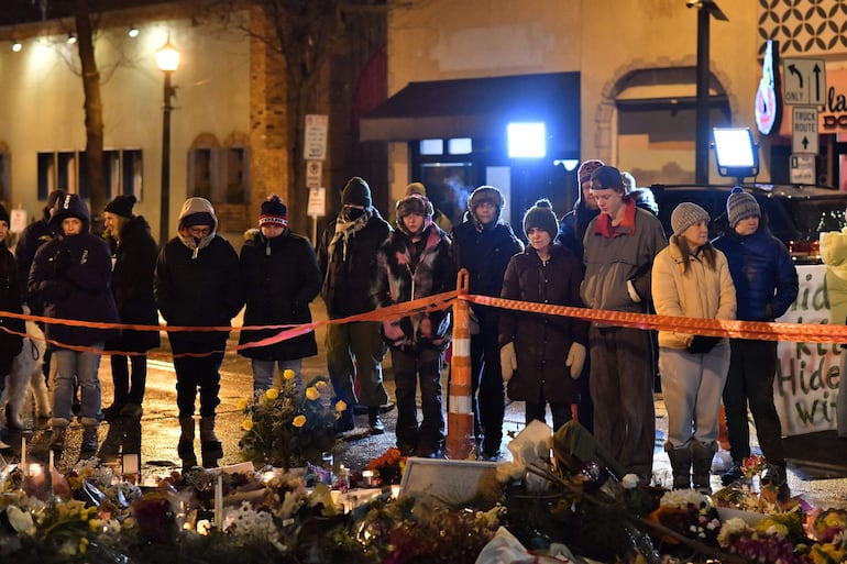 La gente llora en un monumento improvisado en la zona donde Alex Pretti fue asesinado a tiros por agentes federales de inmigración en Minneapolis, Minnesota.