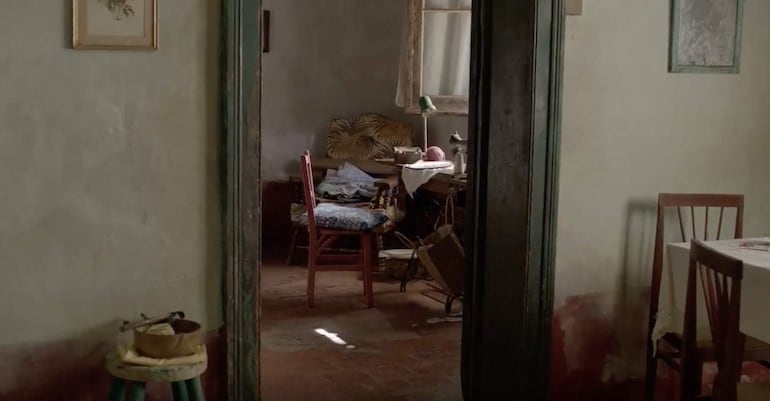 Interior de habitación con sillas, taburete amarillo y luz solar que ilumina el ambiente acogedor.