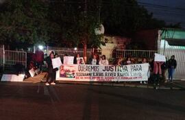 Grupo de mujeres sosteniendo carteles en protesta, algunas con abrigos, en una calle pública.
