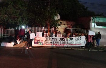 Grupo de mujeres sosteniendo carteles en protesta, algunas con abrigos, en una calle pública.