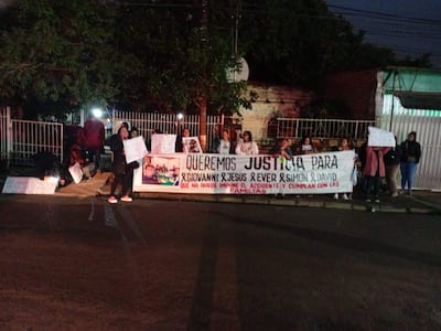 Grupo de mujeres sosteniendo carteles en protesta, algunas con abrigos, en una calle pública.