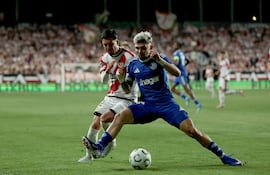 El defensa rumano del Rayo Andrei Ratiu (i) lucha con el paraguayo Julio Enciso, del Estrasburgo, durante el partido de ida de las semifinales de la Liga Conferencia que Rayo Vallecano y Racing Estrasburgo disputan este jueves en el estadio de Vallecas, en Madrid.