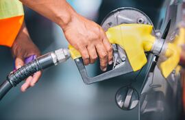Una persona carga combustible en una estación de servicio.