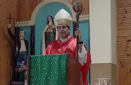 Obispo Gabriel Escobar en túnica roja y mitra, sostiene báculo y micrófono.