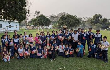 Los niños y niñas de una escuela exhiben con alegría sus regalos que recibieron en la misma institución