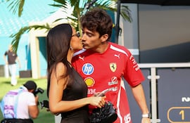 El piloto monegasco de Ferrari, Charles Leclerc, besa a su esposa Alexandra Saint Mleux a su llegada al Miami International Autodrome. (CHARLY TRIBALLEAU / AFP)