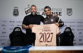 El delantero paraguayo, Ronaldo Martínez sosteniendo la camiseta que oficializa la renovación, junto al presidente de Platense, Sebastián Ordóñez.