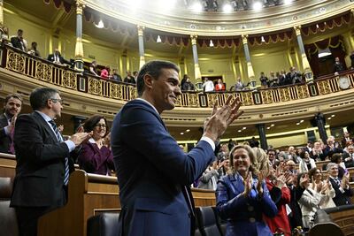 El jefe de Gobierno español, Pedro Sanchez (c) es saludado por los legisladores tras su victoria en las votaciones que le permite seguir liderando. (AFP)