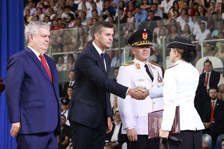 Santiago Peña (c), el ministro del Interior, Enrique Riera (i), y el comandante de la Policía Nacional de Paraguay, Carlos Benítez (2-d), durante una ceremonia este jueves, en Asunción (Paraguay). 