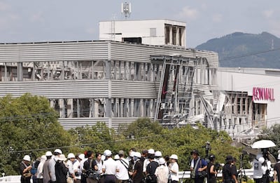 Periodistas informan frente al edificio del Aeon Mall Kumamoto, que resultó dañado por una explosión tras un potente terremoto en Kashima, prefectura de Kumamoto, en el suroeste de Japón, el 30 de julio de 2026.