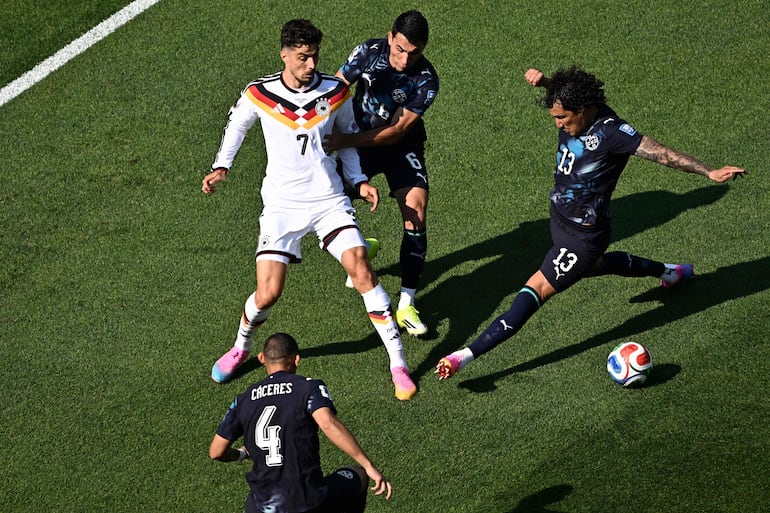 El delantero de Alemania Kai Havertz, el defensa de Paraguay Junior Alonso y el defensa de Paraguay José Canale luchan por el balón durante el partido de fútbol de los dieciseisavos de final de la Copa del Mundo 2026 entre Alemania y Paraguay en el Boston Stadium en Foxborough.