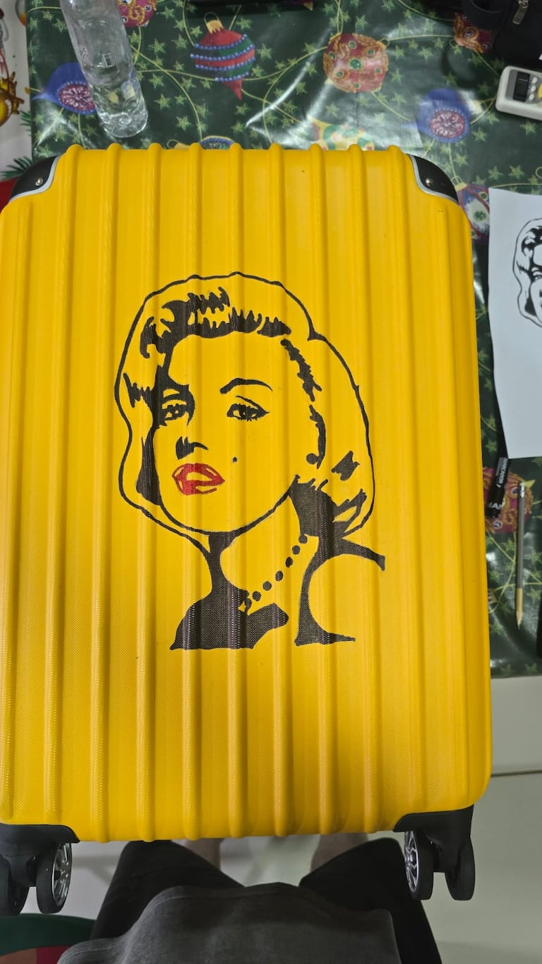La maleta amarilla fue utilizada como lienzo por Carlos Troche para dibujar y pintar a la icónica Marilyn Monroe. (Gentileza)