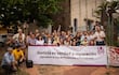 Grupo de personas aplauden con pancarta pidiendo justicia y protección a periodistas en un ambiente sereno.