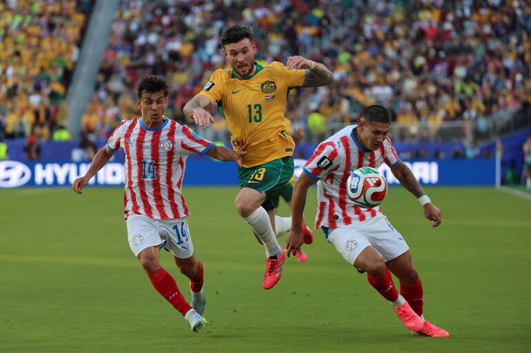 Andrés Cubas (i) y Juan Cáceres (d) de Paraguay disputan el balón con Aiden Oneill (c) de Australia este jueves, en un partido del grupo D del Mundial de la FIFA 2026 entre Paraguay y Australia en el estadio Levi's en Santa Clara, California (Estados Unidos). 