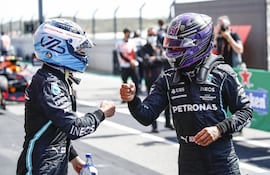 Valtteri Bottas saluda con el puño, en pandemia, al ganador del GP de Portugal en 2021, Lewis Hamilton, de Mercedes.