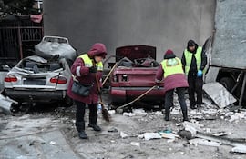 Obreros limpian escombros en un edificio residencial dañado por un bombardeo ruso en Járkov.