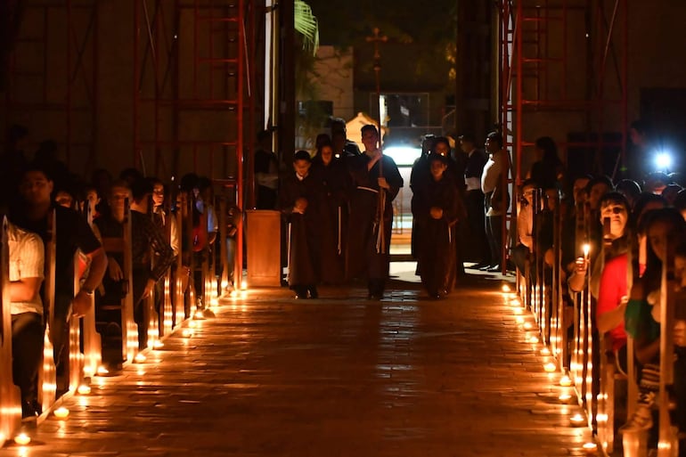 La misa se desarrolla a la luz de candiles y los celebrantes ingresan al templo con la indumentaria propia de la época de las reducciones.