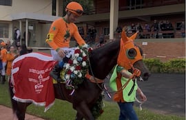 El jockey argentino Gustavo Calvente sonríe luego de alzarse con el premio Gran Derby Asunción con la potranca 2 años Show Emotion del stud 8 Años.