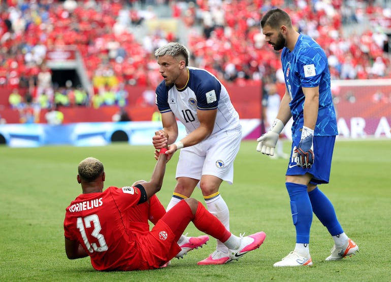 Derek Cornelius recibe la asistencia del bosnio Ermedin Demirovic que lo ayuda a levantarse después de sufrir una infracción.
