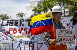 Una mujer sostiene un cartel durante un viacrucis para pedir por la liberación de 170 trabajadores de la estatal Pdvsa, detenidos entre 2024 y 2025, este viernes, a las afueras del Tribunal Supremo de Justicia (TSJ) en Caracas.