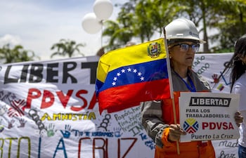 Una mujer sostiene un cartel durante un viacrucis para pedir por la liberación de 170 trabajadores de la estatal Pdvsa, detenidos entre 2024 y 2025, este viernes, a las afueras del Tribunal Supremo de Justicia (TSJ) en Caracas.