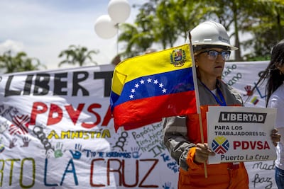 Una mujer sostiene un cartel durante un viacrucis para pedir por la liberación de 170 trabajadores de la estatal Pdvsa, detenidos entre 2024 y 2025, este viernes, a las afueras del Tribunal Supremo de Justicia (TSJ) en Caracas.