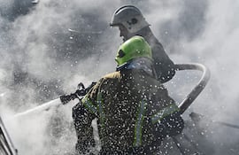 Bomberos trabajan en el sitio de un bombardeo ruso sobre la localidad de Brovary, cerca de Kiev, este sábado.
