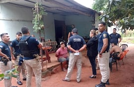 Seis policías conversan con un hombre sentado en un entorno rural, junto a una motocicleta en el fondo.