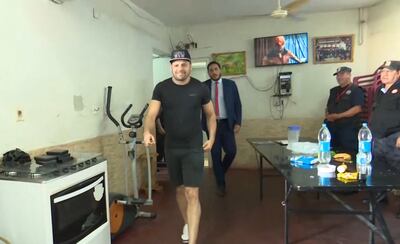 Reinaldo Javier Cabaña Santacruz, alias Cucho, camina sonriente dentro de la celda vip, durante la verificación. Detrás, Joaquín González, director de Establecimientos  Penitenciarios.