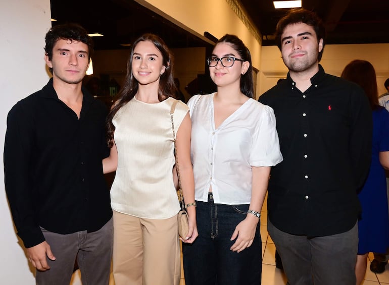 La imagen muestra a tres mujeres posando juntas en un entorno interior bien iluminado. La primera mujer, a la izquierda, tiene el cabello largo y oscuro, lleva una blusa negra y un blazer rosa junto con jeans. La mujer del centro tiene el cabello corto y oscuro, viste un vestido con un patrón floral en colores verdes y azules, complementado por un blazer negro. La tercera mujer, a la derecha, tiene cabello largo y lleva una blusa negra con un blazer rosa. 

Todas están sonriendo y parecen estar en un ambiente social o de evento, posiblemente una reunión o celebración. No se observan elementos que identifiquen a un equipo de fútbol, ni lugares, monumentos o estadios reconocibles. No hay texto visible ni objetos relevantes de contexto noticioso en la imagen.