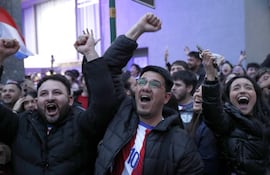 Aficionados reaccionan durante la transmisión del partido del Mundial de la FIFA 2026 entre Alemania y Paraguay este lunes en una calle de Asunción (Paraguay).