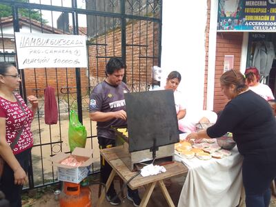Los vecinos vendiendo hamburguesas para recaudar fondos y comprar las cámaras de circuito cerrado.