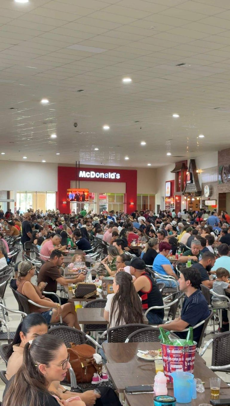 Comensales en McDonald's charlan y disfrutan de alimentos en familia.