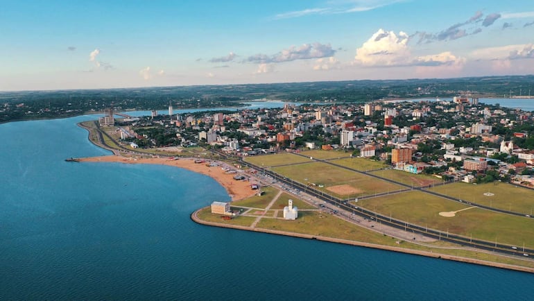 Vista panorámica de Encarnación, costa con edificios variados y un camino junto a la playa en un día parcialmente nublado.