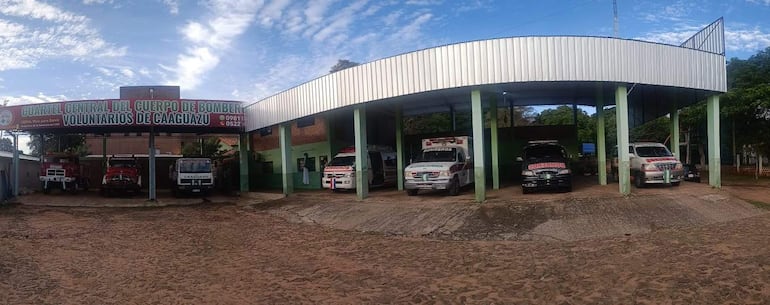 Guarita del Cuerpo de Bomberos Voluntarios de Caaguazú con camiones de bomberos alineados en un día soleado.