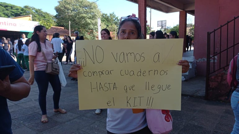 Madre muestra un cartel de protesta ante la desesperación por la falta de útiles.