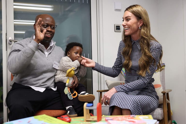 La princesa Kate Middleton hablando con Andy Apraku y su hijo de ocho meses, Judah, de Croydon, durante una visita a la organización benéfica de salud mental infantil Anna Freud en el norte de Londres. (Geoff PUGH / POOL / AFP)