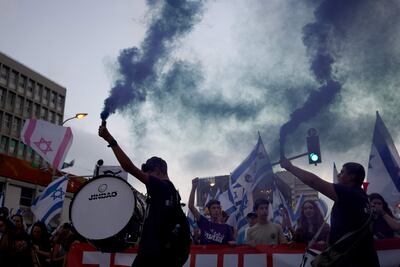 Manifestantes encienden bengalas y ondean banderas durante una protesta antigubernamental en Tel Aviv, Israel.