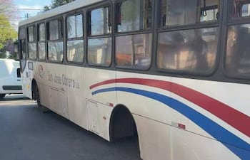 Autobús de San José Obrero S.A. estacionado en la calle, decorado en rojo y azul, sin pasajeros visibles.