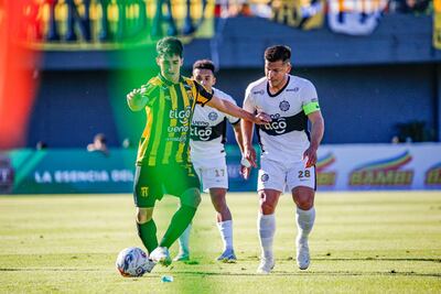 El talentoso mediocapista de Guaraní, Agustín Manzur maneja el esférico ante la presencia del volante franjeado, Hugo Quintana.