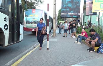 Pasajeros aguardan los autobuses que los llevarán a sus destinos, en la vereda de la avenida Aviadores del Chaco, en la zona de los shoppings. Debido a la “regulada” de las empresas ayer habrán demorado en llegar.