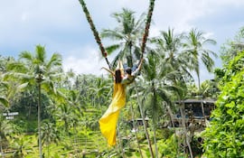 Jóvenes turistas disfrutan del columpio en la terraza de arroz tegalalang en Bali, Indonesia.