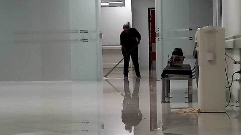 Con escurridor en mano, una de las funcionarias del IPS, San Juan, tratando de sacar el agua.