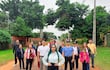 Mujer con blusa blanca y falda negra rodeada de un grupo en la calle, mostrando expresiones de alegría y tranquilidad.