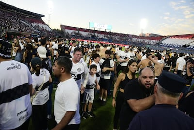 Los aficionados de Olimpia invadiendo el campo de juego del estadio Defensores del Chaco para resguardarse de los gases lacrimógenos.