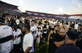 Los aficionados de Olimpia invadiendo el campo de juego del estadio Defensores del Chaco para resguardarse de los gases lacrimógenos.