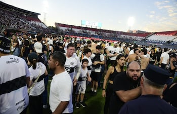 Los aficionados de Olimpia invadiendo el campo de juego del estadio Defensores del Chaco para resguardarse de los gases lacrimógenos.